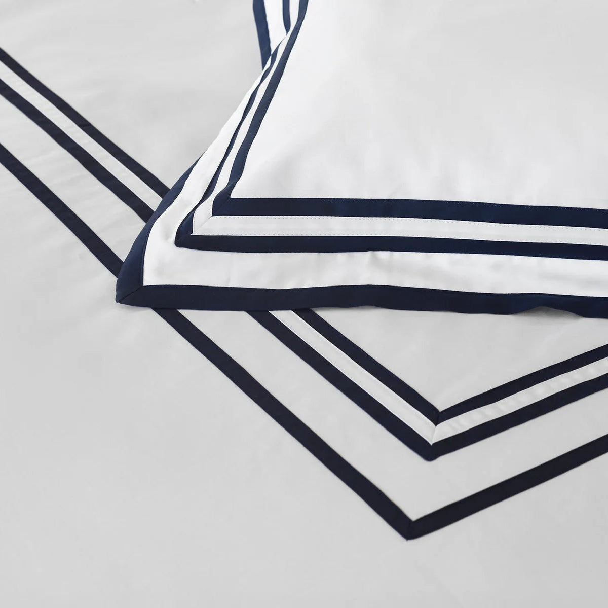 Close up of Sonata white midnight pillowcase sham on a light gray background