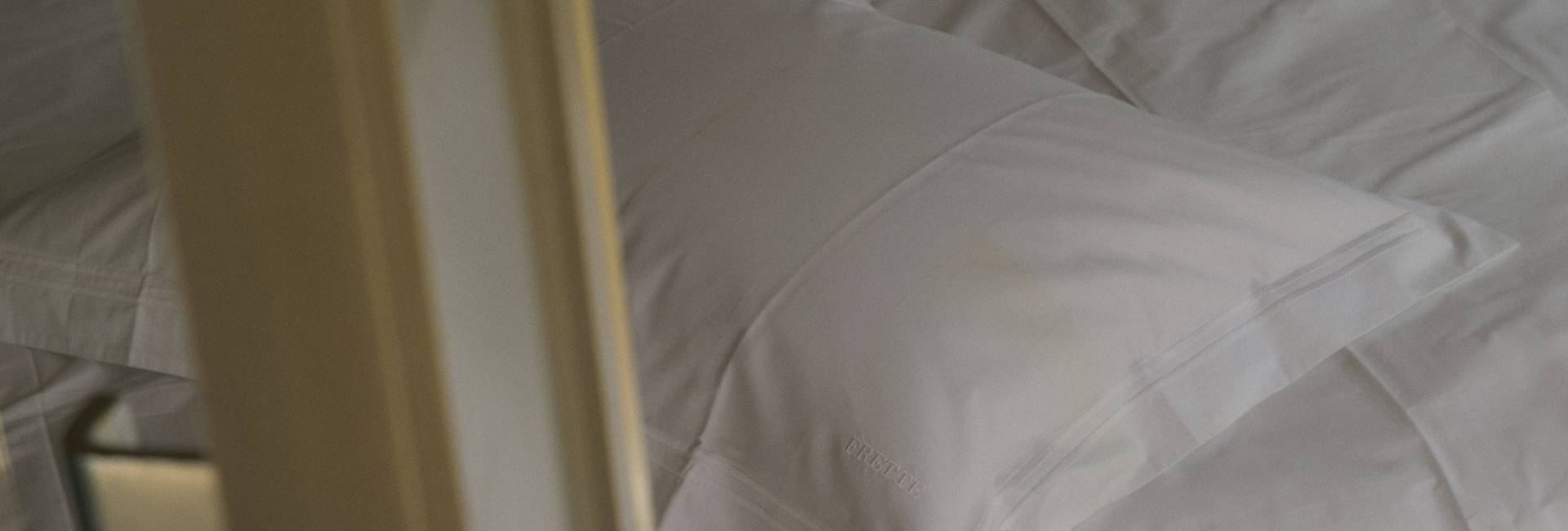 Close-up of white pillows on a bed with a blurred background